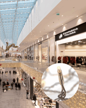 Indendørs shoppingcenter med julebelysning i form af indendørs istaplyskæder med varmt hvidt lys.
