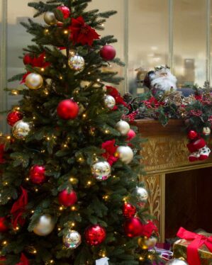Julemiljø med juletræ i plastik pyntet med julekugler og julestjerner.