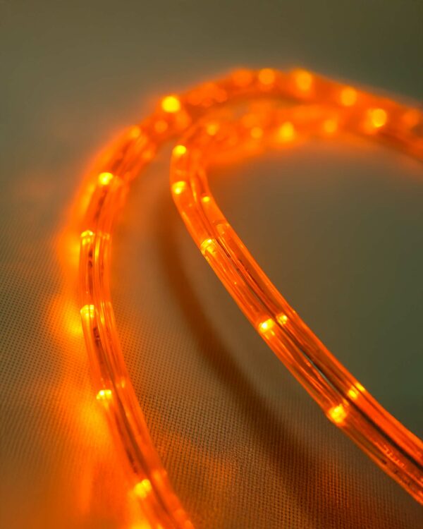 Nærbillede af fleksibel orange LED-ropelight med stærk glød, ideel til udendørs brug og dekorative lysinstallationer med høj synlighed og holdbarhed.
