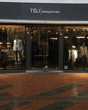 Tøjeksperten butik med istaplyskæder som julebelysning i vinteren.