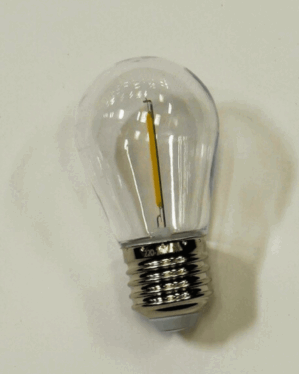 Klar varm hvid LED-pære med E27 sokkel og filament, placeret på hvid baggrund. Perfekt til dekorativ udendørs belysning i festoon-lyskæder og andre armaturer.