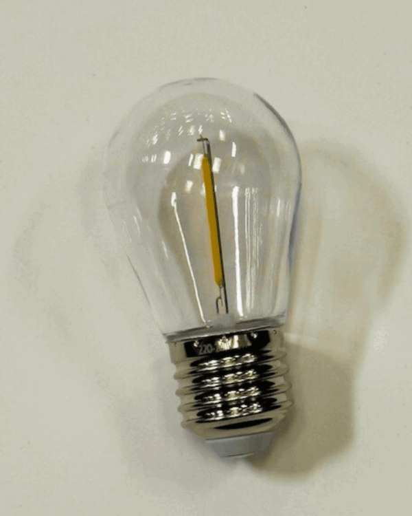 Klar varm hvid LED-pære med E27 sokkel og filament, placeret på hvid baggrund. Perfekt til dekorativ udendørs belysning i festoon-lyskæder og andre armaturer.