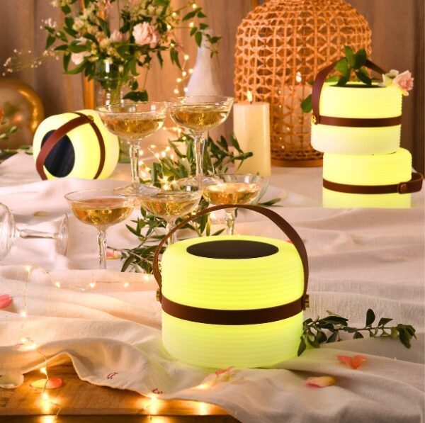 Fint sommerbord med transportabel lampe der lyser med farvet lys.