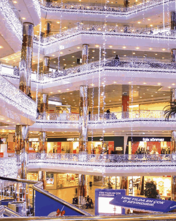 Indendørs shoppingcenter med julebelysning på gelænderet i form af LED lysgardin lyskæder med koldt hvidt lys.