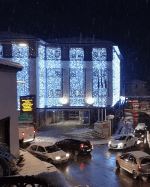 Store lysgardiner på høj facade med koldt hvidt lys som julebelysning