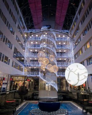 Indendørs centerudsmykning med hvide LED-lysgardiner og gyldne kuglemotiver i flere etager. Nærbillede viser energieffektive LED på hvid ledning, perfekt til professionel julebelysning.