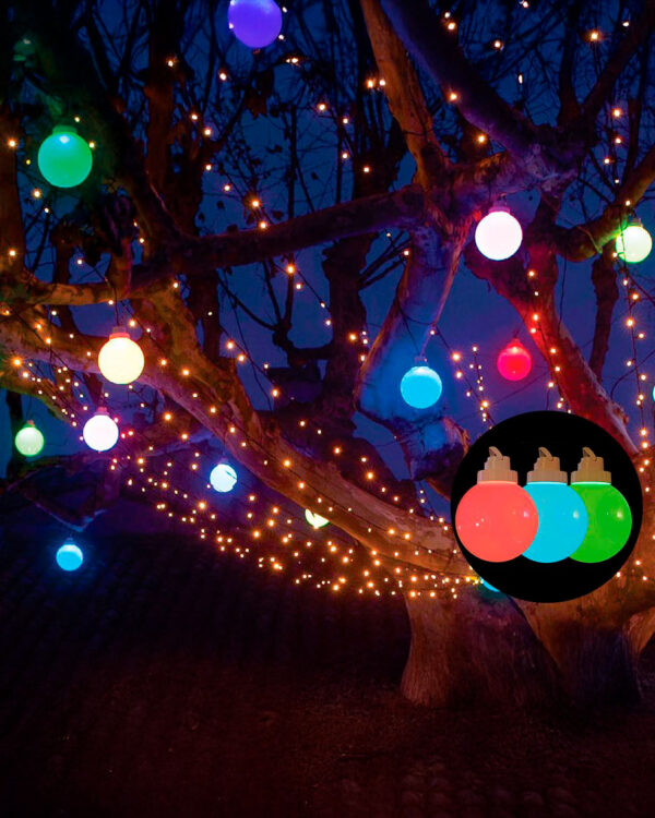 Træ udsmykket med farvede LED-julekugler i blå, grøn, rød og lilla samt gyldne lyskæder, skaber festlig stemning udendørs om aftenen, med produktnærbillede inkluderet.