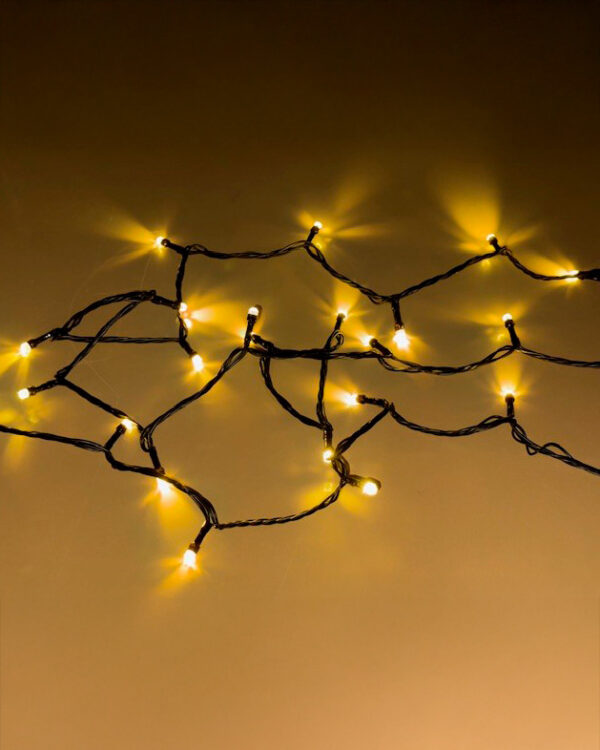 Klyngelyskæde med varm hvid LED-belysning, tæt monteret på sort kabel. Skaber et elegant og hyggeligt lysudtryk, ideelt til både indendørs og udendørs dekoration.