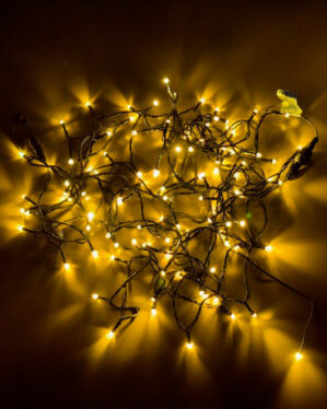 Klyngelyskæde med varm hvid LED-belysning, tæt forbundet på sort kabel. Skaber intens lysstyrke og hyggelig atmosfære, velegnet til både indendørs og udendørs dekoration.