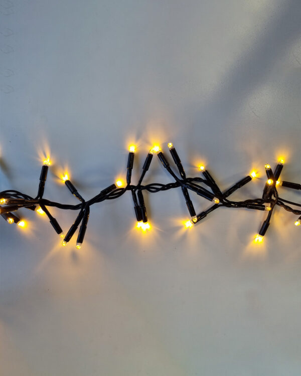 Dual color i varm hvid LED-lyskæde med sort kabel, der udsender et blødt, gyldent skær. Skaber en hyggelig og indbydende atmosfære til både indendørs og udendørs dekoration.