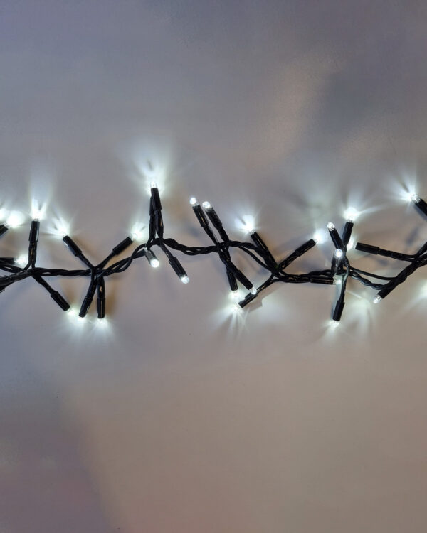 Dual color i kold hvid LED-lyskæde med sort kabel, der udsender et klart og moderne lys. Ideel til professionel julebelysning, facader eller vinterlige udendørs dekorationer.