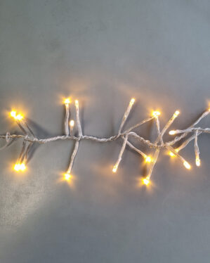 Klyngelyskæde med varm hvid LED-belysning og transparent kabel, der giver et blødt og hyggeligt lys - ideel til juletræer, facader og indendørs dekoration.