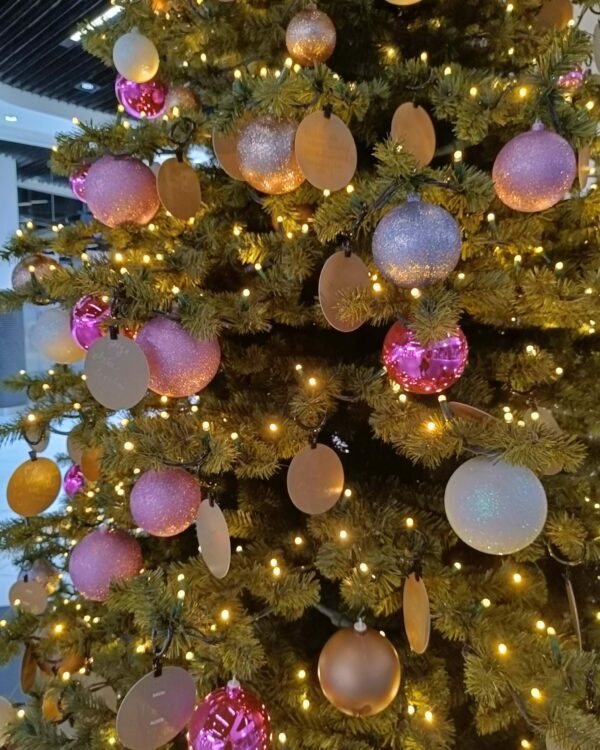 Kunstigt juletræ dekoreret med varme hvide LED-lyskæder, guld- og rosa julekugler samt matte vedhæng. Skaber et elegant og moderne udtryk til professionel juleudsmykning.