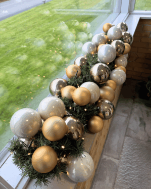 Elegant granguirlande pyntet med kugler i perlemor, guld og sølv samt varm hvid LED-lyskæde. Ideel til vinduesudsmykning eller julebord.