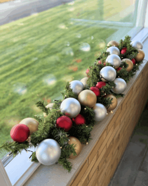 Elegant juleguirlande dekoreret med kugler i rød, champagne og sølv. Den grønne gran og LED-lyskæde skaber en klassisk og hyggelig julestemning.