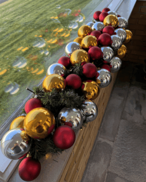 Elegant juleguirlande med røde, guld- og sølvkugler samt LED-lys. Perfekt som eksklusiv vinduespynt, der skaber klassisk julestemning med varme farver.