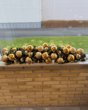 Eksklusiv juleguirlande i guld og champagne med skinnende og matte kugler, naturtro gran og varm LED-belysning. Perfekt til vindueskarme, receptioner eller festlige dekorationer.