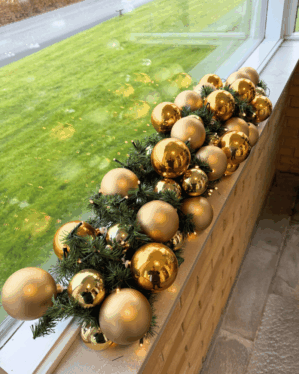 Elegant juleguirlande i guld og champagne med matte og blanke kugler samt varm LED-belysning. Perfekt som luksuriøs dekoration i vindueskarm eller på receptionens disk.