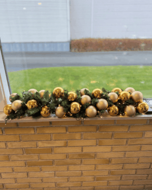 Færdigpyntet granguirlande med guld- og champagnefarvede julekugler samt varm hvid LED-lyskæde. Perfekt til vindueskarm, borddekoration eller elegant juleudsmykning uden strømtilslutning.