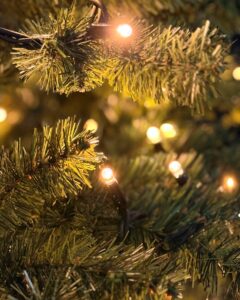 Detalje af kunstigt juletræ fra Exclusive-serien med tæt grøn nålestruktur og Jada light PRO varm hvid LED-lyskæde, hvor små pærer giver blødt, stemningsfuldt lys og fremhæver grenene tæt.