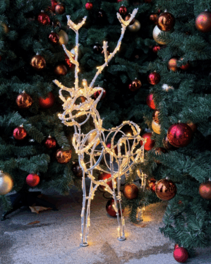 Mini Stag julemotiv i aluminium med LED lys der gemmer sig i en klynge pyntede juletræer.