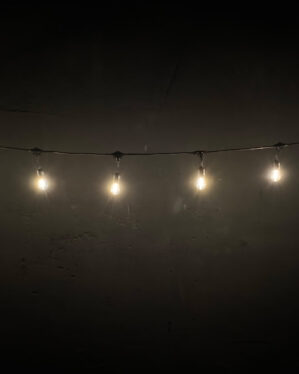 LED party-lyskæde med varme hvide filamentpærer på sort kabel i retrostil, jævnt fordelt og velegnet til dekorativ belysning i caféer, terrasser og events.