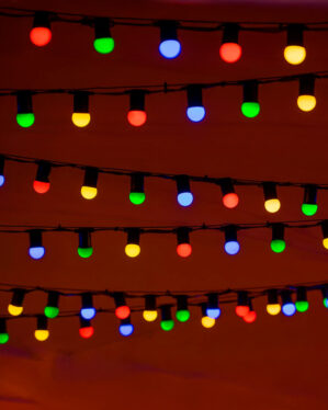 Party- lyskæder med farvede LED-pærer i rød, grøn, blå og gul ophængt i rækker, der skaber en livlig og stemningsfuld belysning til fest og udendørs miljøer.